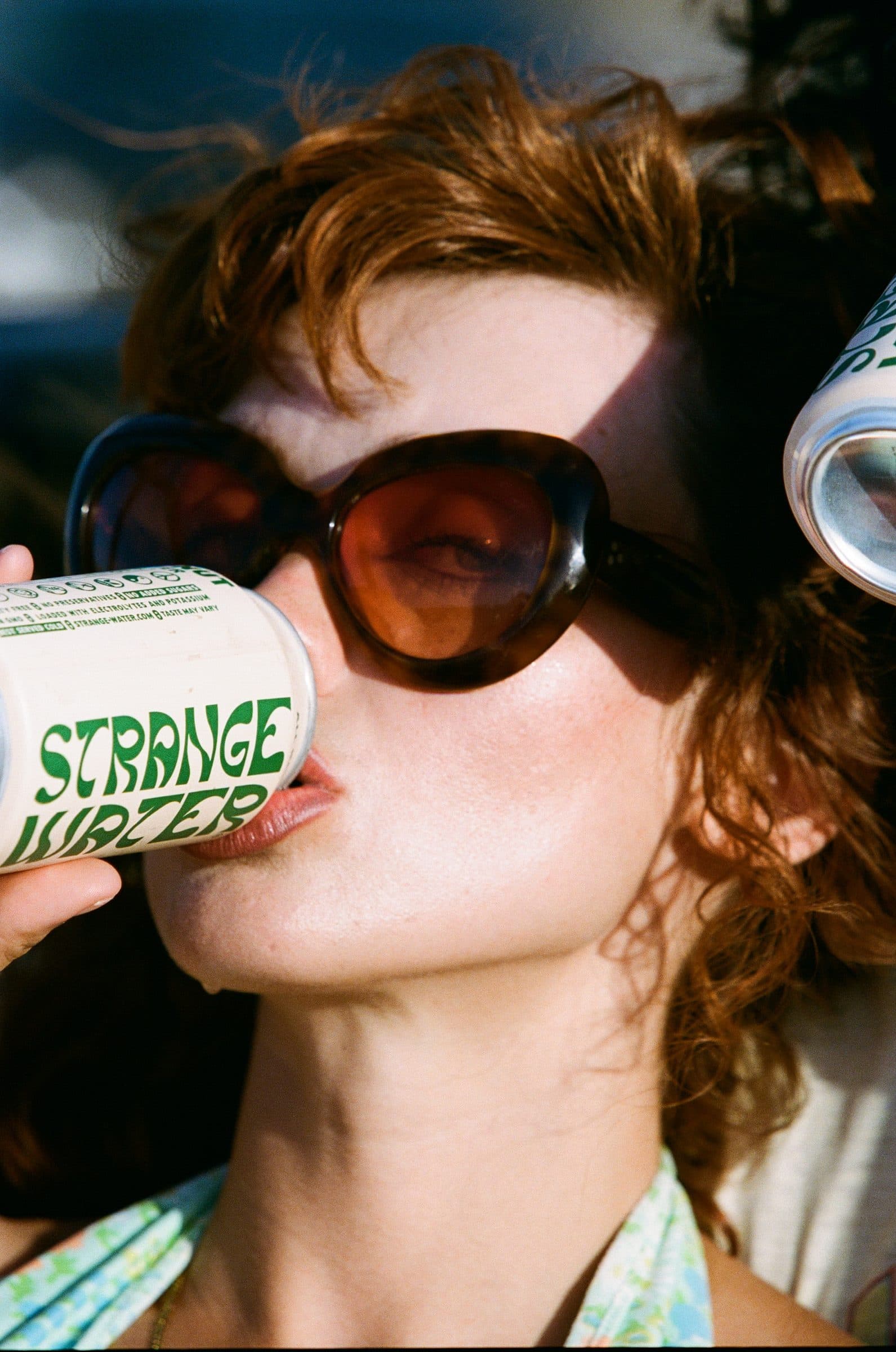 Drinking a can of Strange Water in the sun